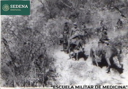 Imagen de Cadetes de la brigada médica de la Escuela Médico Militar transitan a caballo por un sendero boscoso para ir de una comunidad a otra (atribuido)