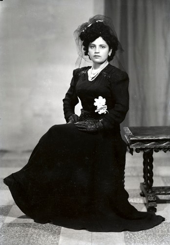 Imagen de Retrato de mujer joven con vestido elegante, guantes y sombrero en estudio (atribuido)