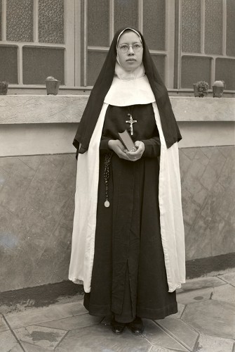 Imagen de Retrato de mujer joven con hábito religioso en patio, posiblemente una escuela (atribuido)