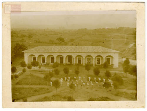 Imagen de Vista panorámica de escuela y alumnos formados en el jardín. Tétela, Puebla