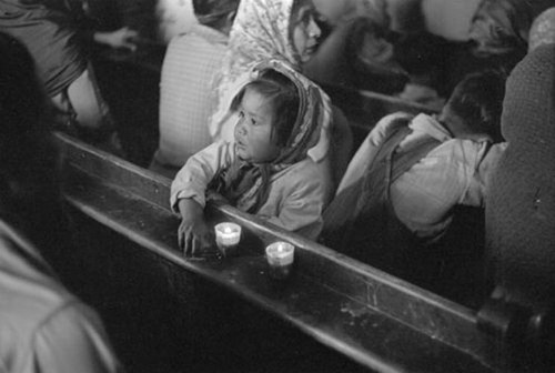 Imagen de Niña sentada en una banca durante una misa en la Basílica de Guadalupe (atribuido)