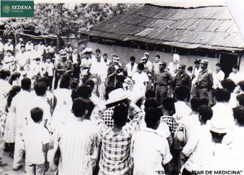 Imagen de El general de brigada Salvador Rangel Medina, acompañado de cadetes y una enfermera, toma la palabra frente a decenas de hombres y niños (atribuido)
