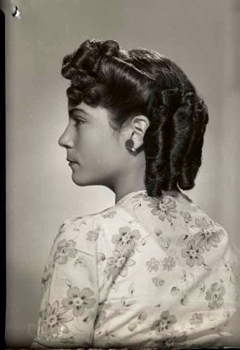 Imagen de Retrato de perfil de niña con vestido estampado y peinado con bucles y aretes en estudio (atribuido)