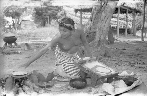Imagen de Mujer indígena semidesnuda moliendo en un metate (propio)